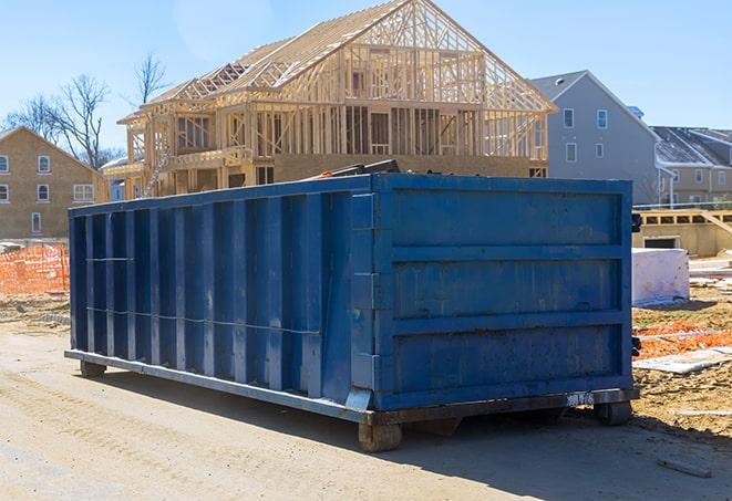 a residential dumpster waiting outside a renovation project